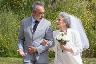Man in Gray Suit Holding White Rose Bouquet