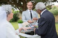 Man in Black Suit Jacket Holding White Flower Bouquet