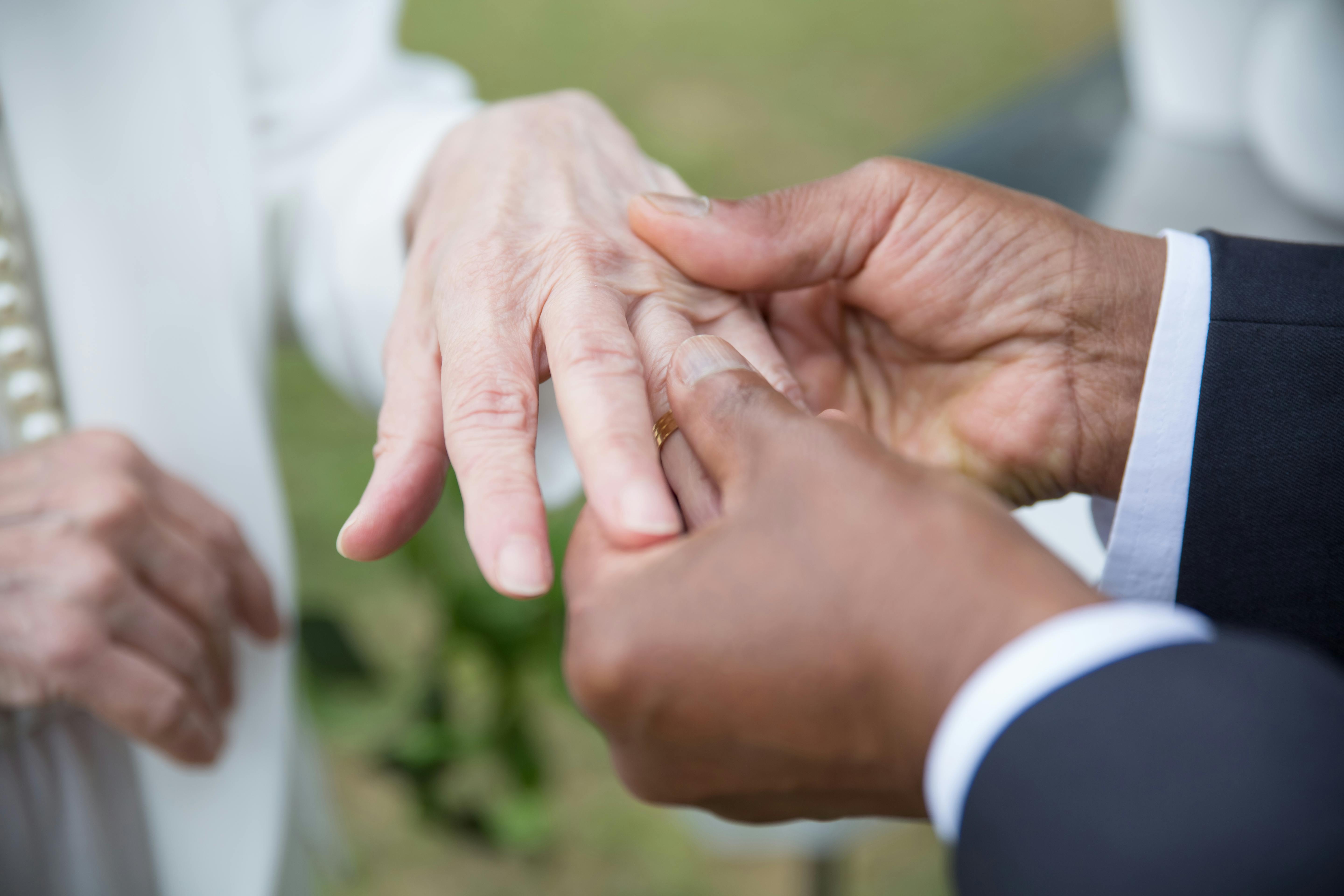 man putting a wedding ring to a woman