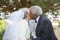 Man in Black Suit Jacket Kissing Woman in White Wedding Dress