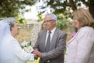 Man in Black Suit Holding Bouquet of Flowers