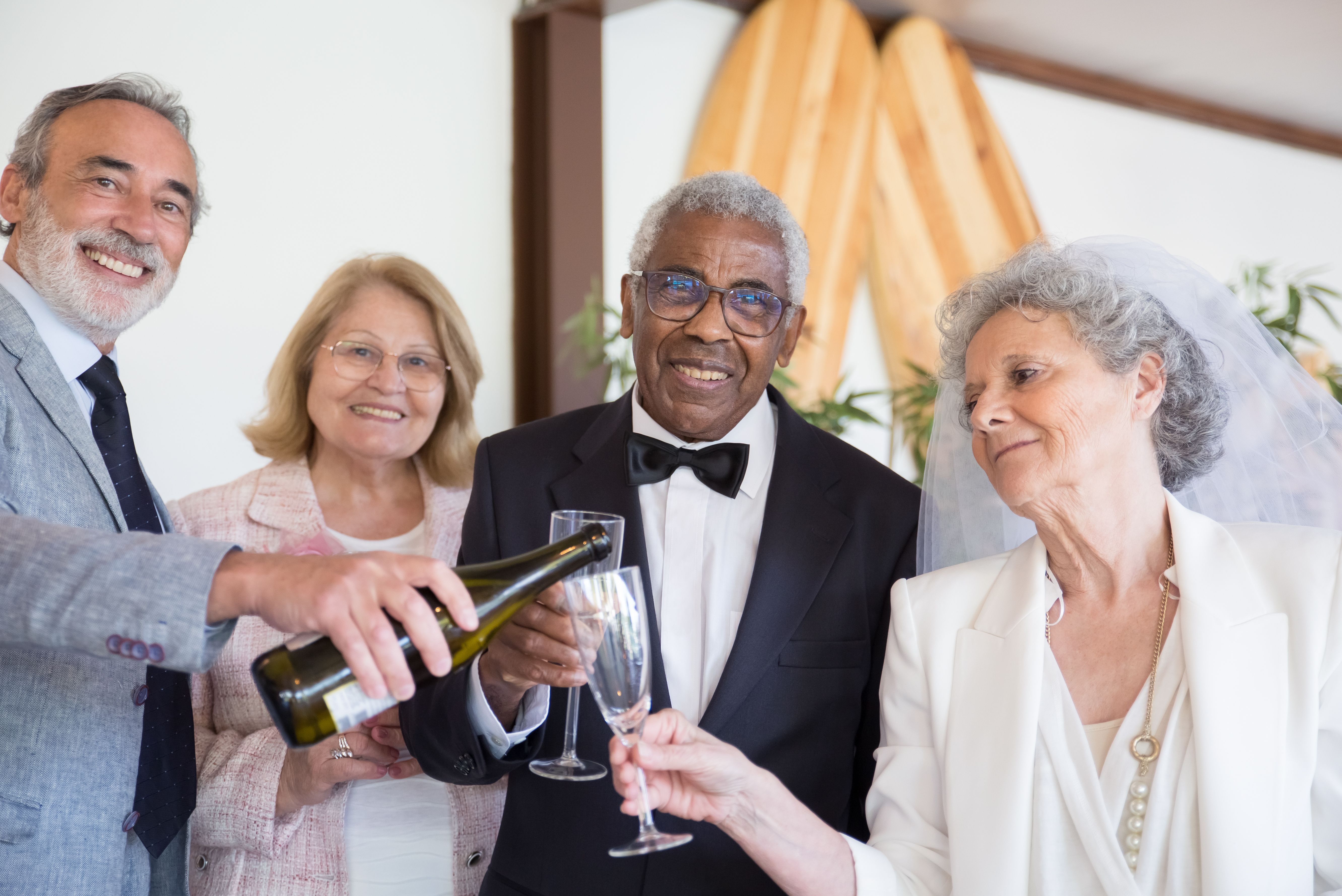 A joyous wedding celebration featuring a couple with friends, dressed elegantly and toasting with champagne.