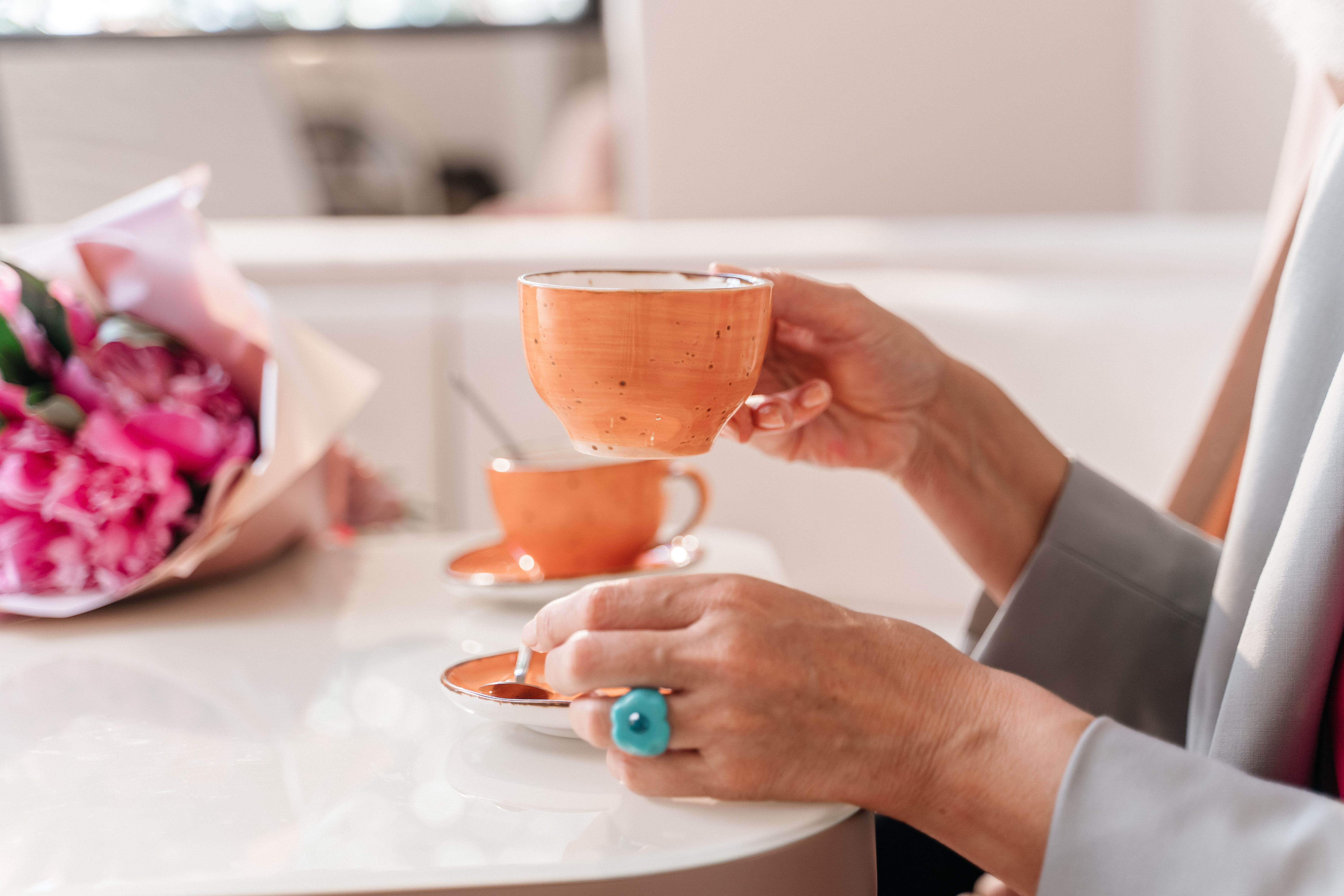 A Person in Gray Blazer Holding Cup of Coffee · Free Stock Photo