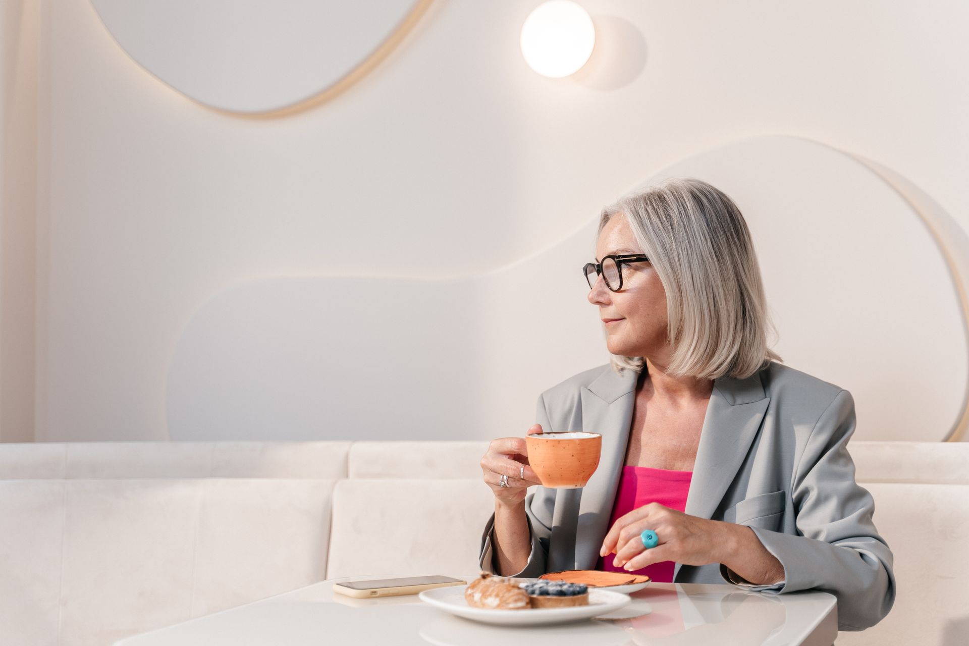 Woman in Black Framed Eyeglasses Holding Brown Ceramic Mug
