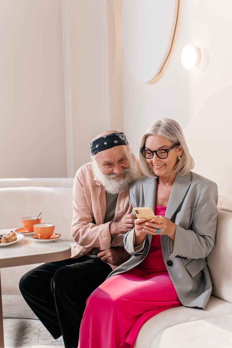 Photo Of An Elderly Couple Looking At A Cell Phone Together