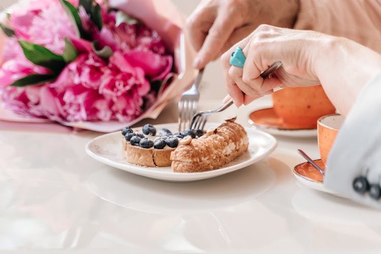 Close Up Of Hands Eating Bread With Fruit