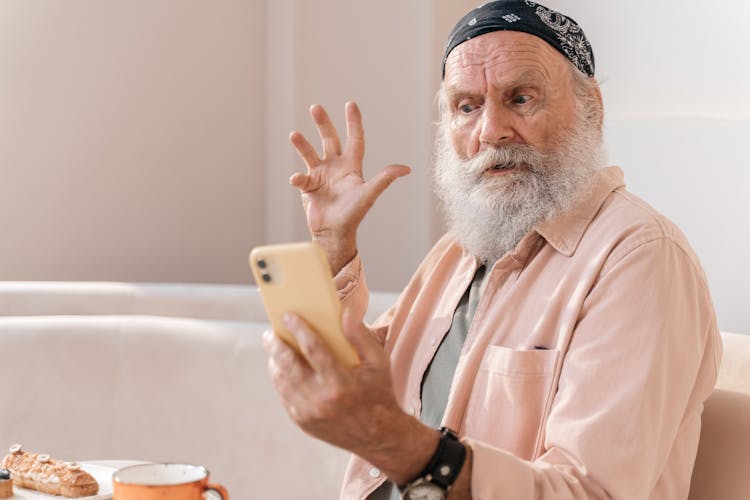 A Shocked Man Holding A Smartphone 