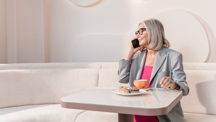 Woman In Gray Blazer Holding A Smartphone To Her Ear 