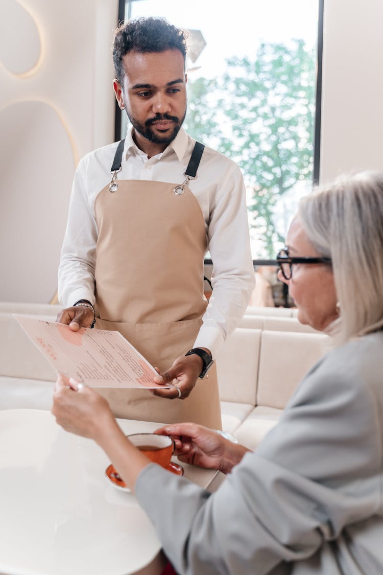 Waiter Showing Menu To Woman