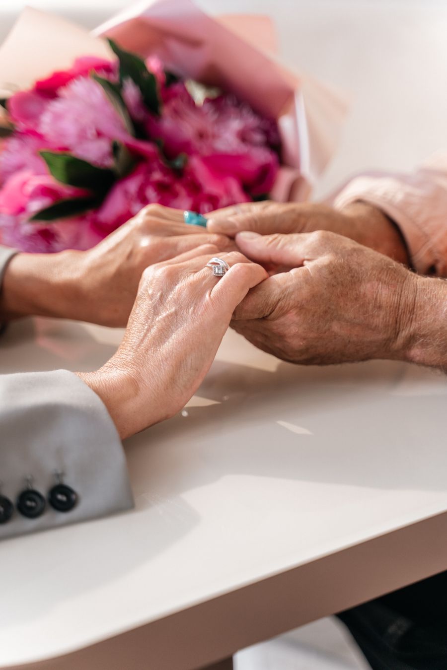 Young and elderly hands clasped together in gentle comfort