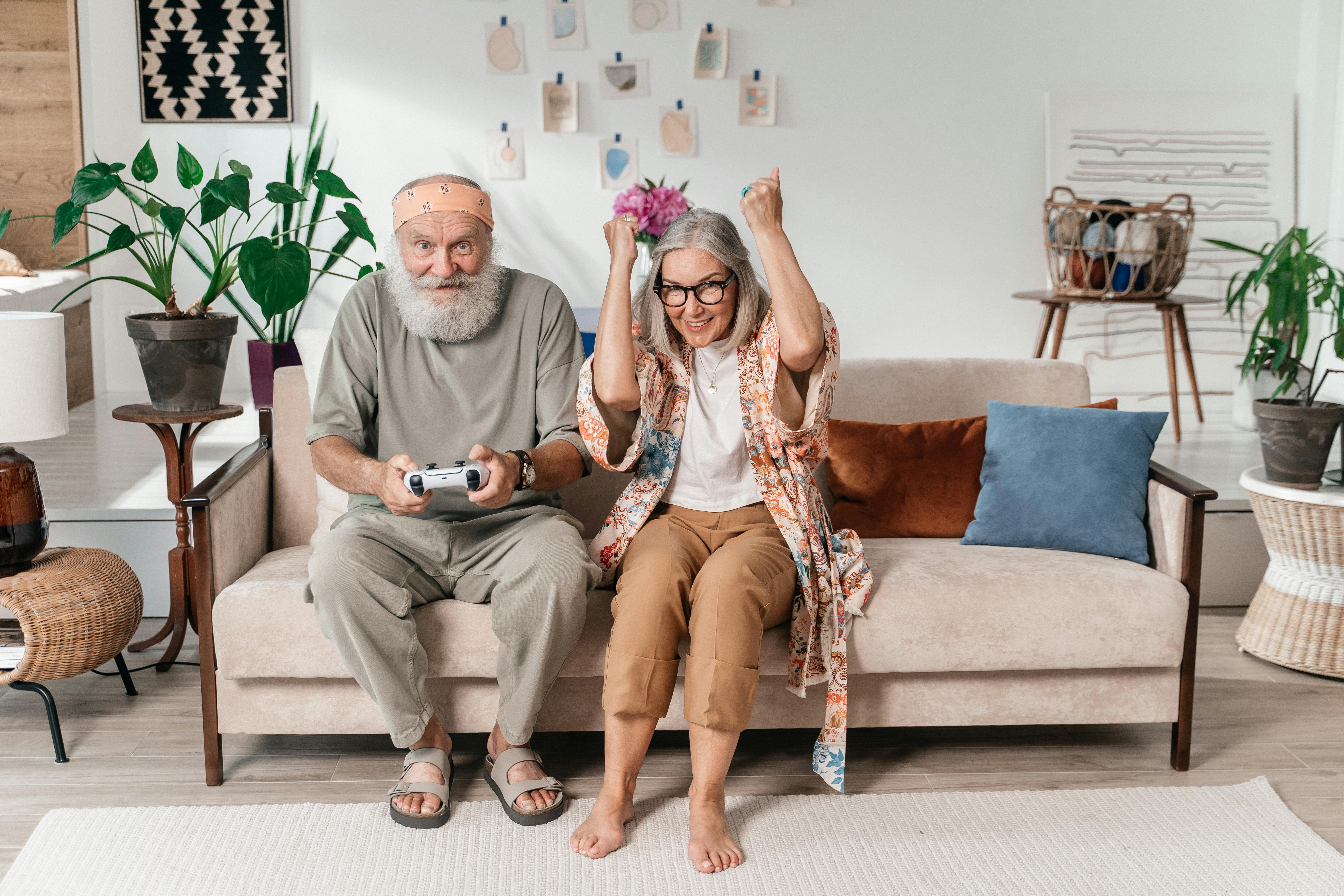 smiling old couple plating video games at home