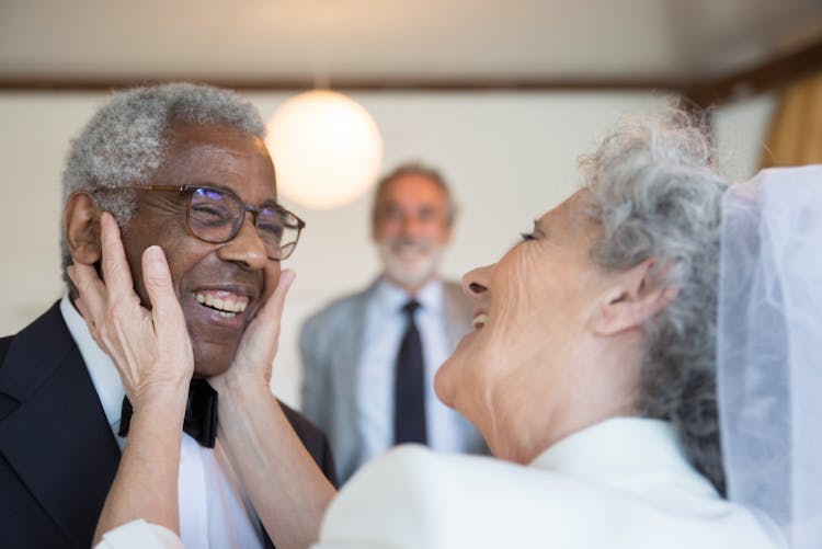 Elderly Woman Holding The Face Of An Elderly Man