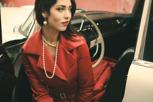 A Woman in Red Dress Sitting on Drivers Seat