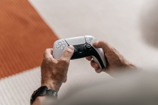 Close-up of a senior adult's hands holding a video game controller on a textured background.