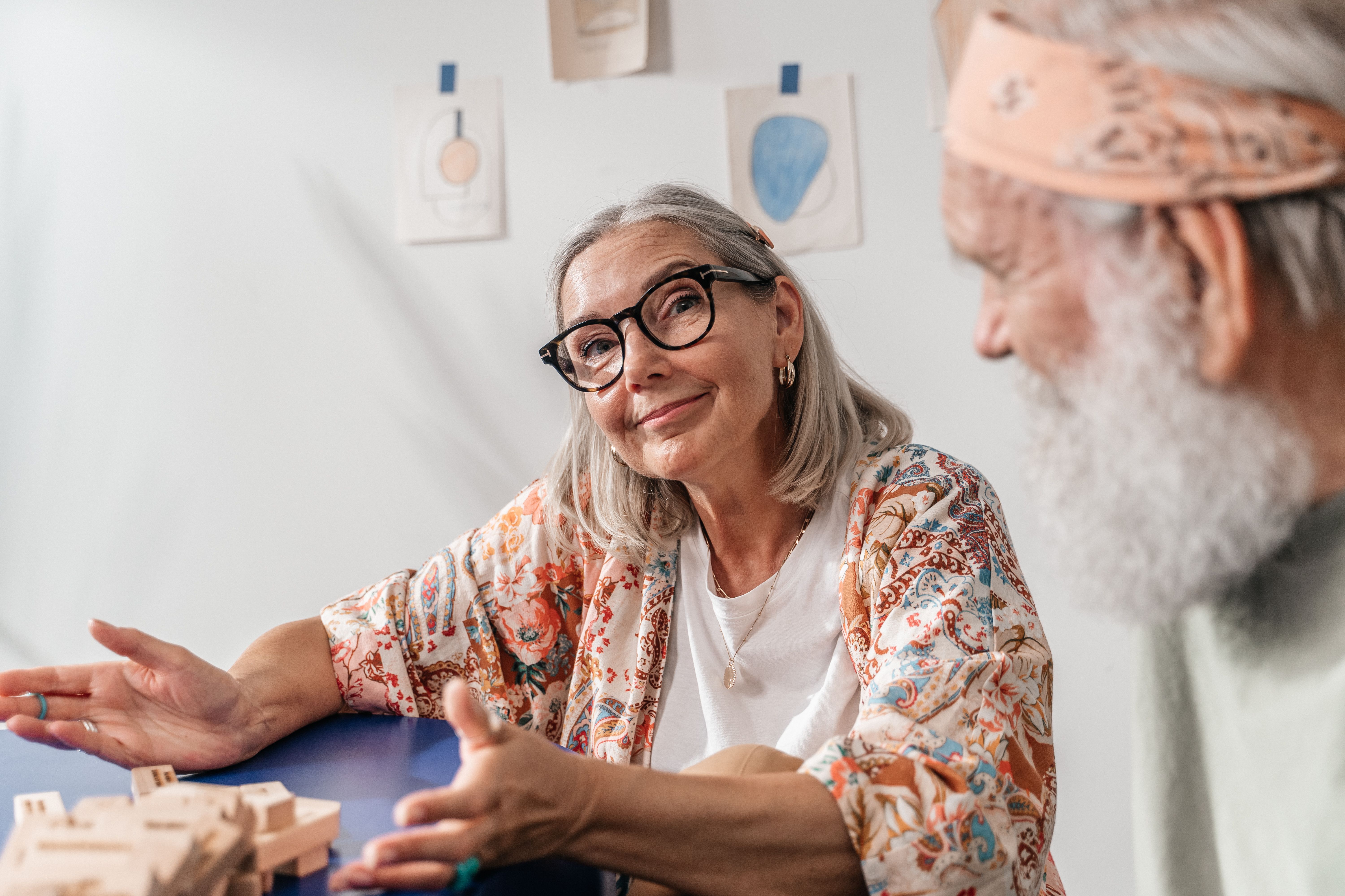 Senior couple relaxing and playing games together indoors, capturing affectionate and joyful moments, illustrating Adult Family Homes Near Me — 1-800-MEDIGAP, America's Trusted Toll-Free Number.