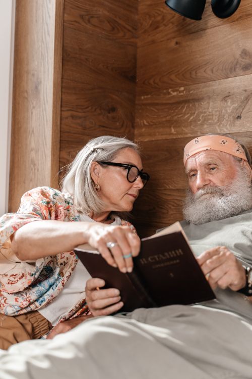 Free Senior couple enjoys quiet time reading together in a cozy wooden nook. Stock Photo