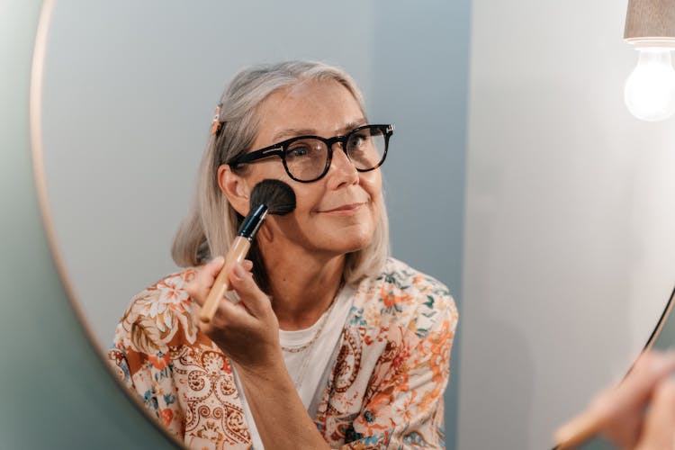 Elderly Woman Doing Her Makeup In Mirror