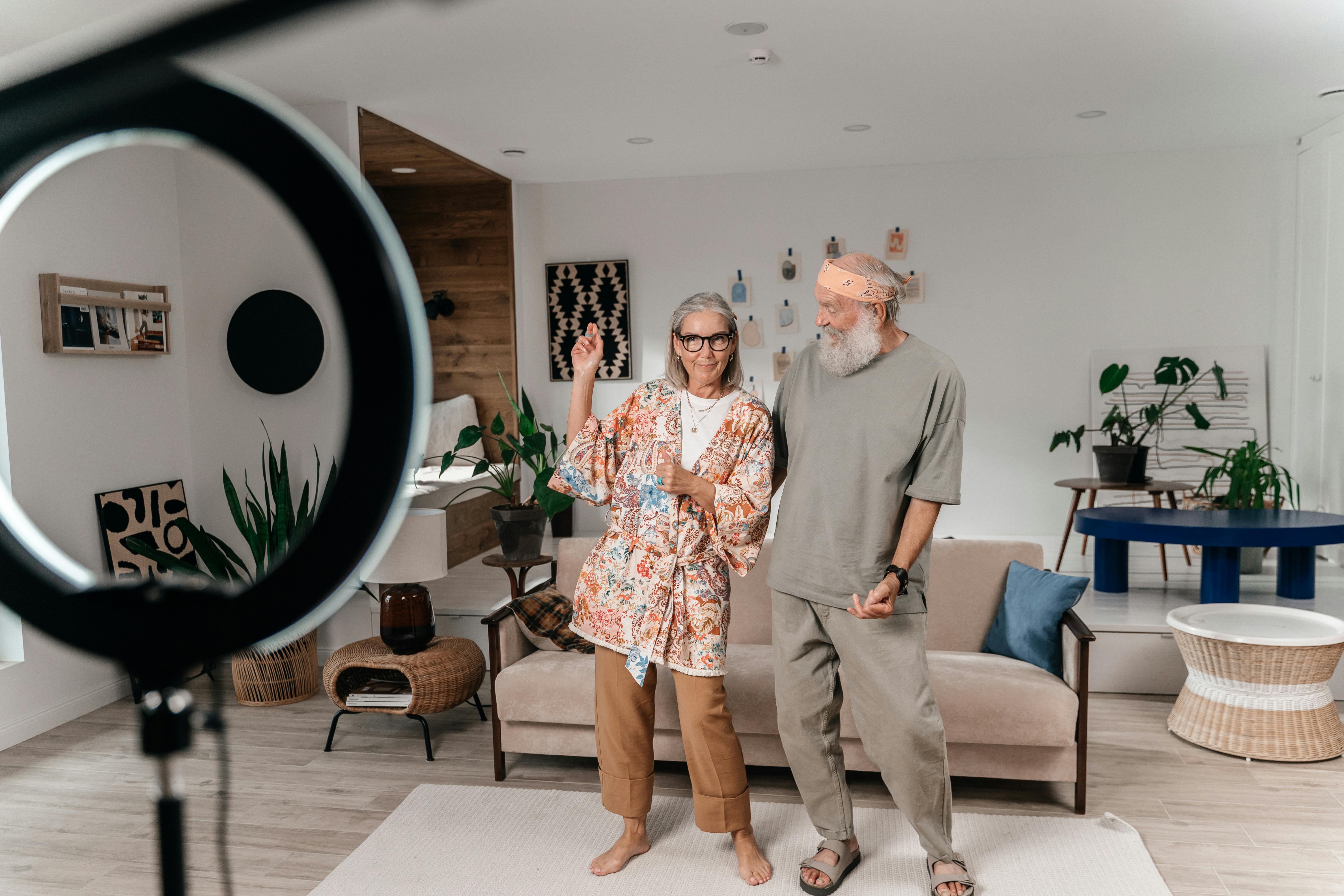 A cheerful senior couple posing together in a modern, stylish living room setting.