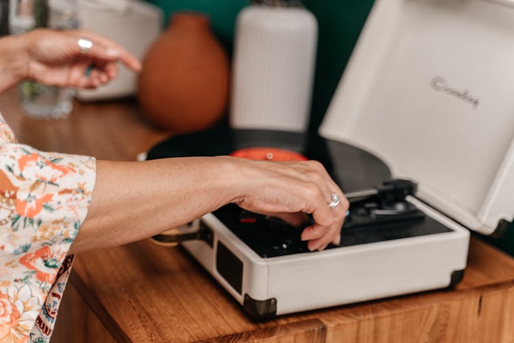 Hands Turning On Record Player