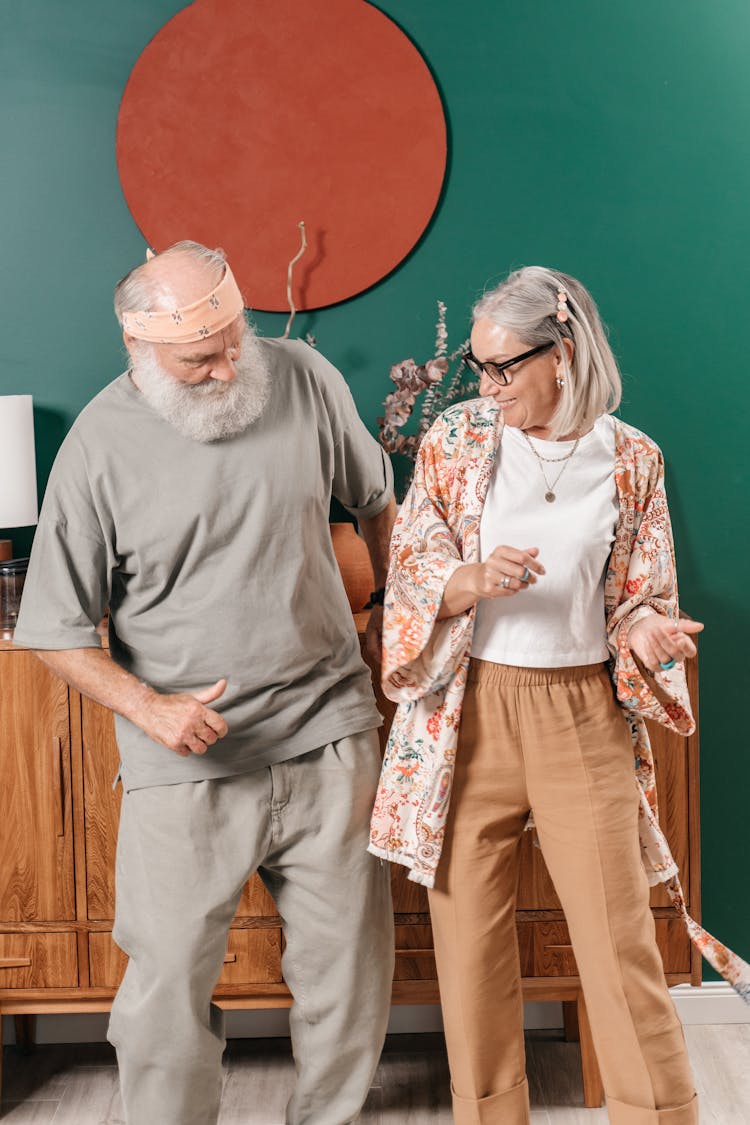 Smiling Elderly Couple Dancing At Home