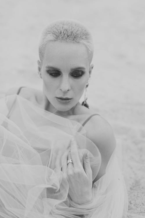 Free Black and White Photo of a Woman Lying Down on Sand Stock Photo