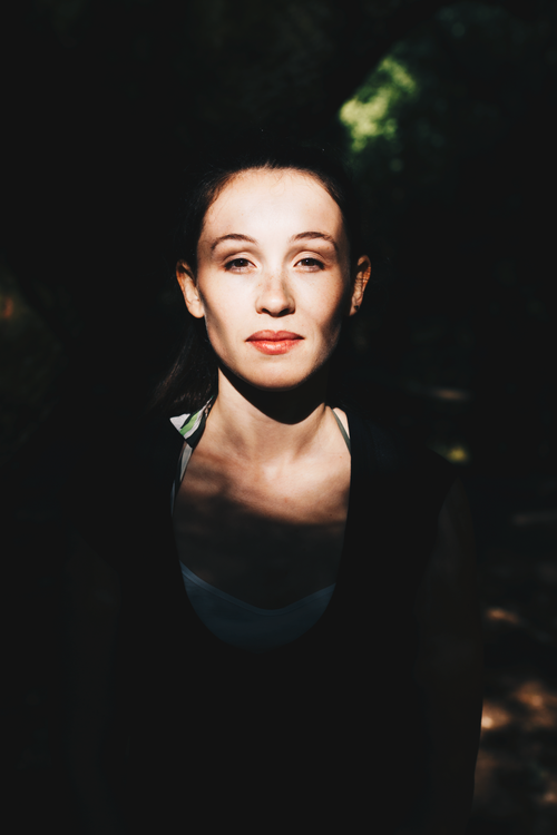 Free Striking portrait of a woman in shadow with natural light on her face. Stock Photo
