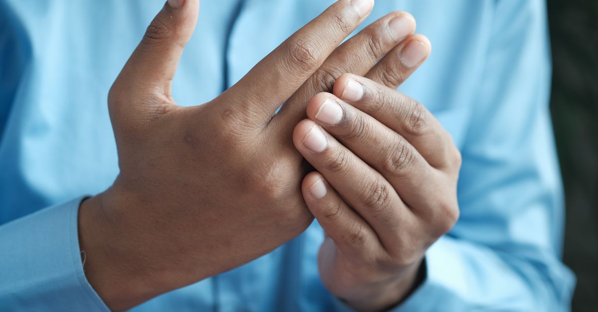 Close-up of a man gently holding his hand, symbolizing comfort or pain relief.