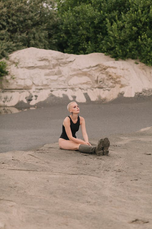 Beautiful Woman in Blank Top Sitting on Sand