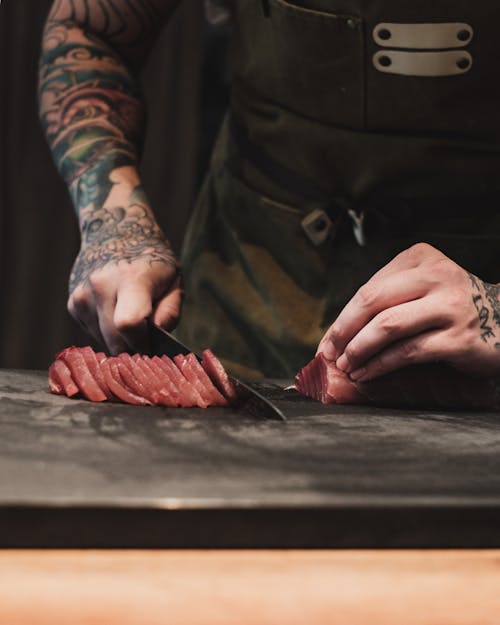 Free Hands of a Person Slicing Meat Stock Photo