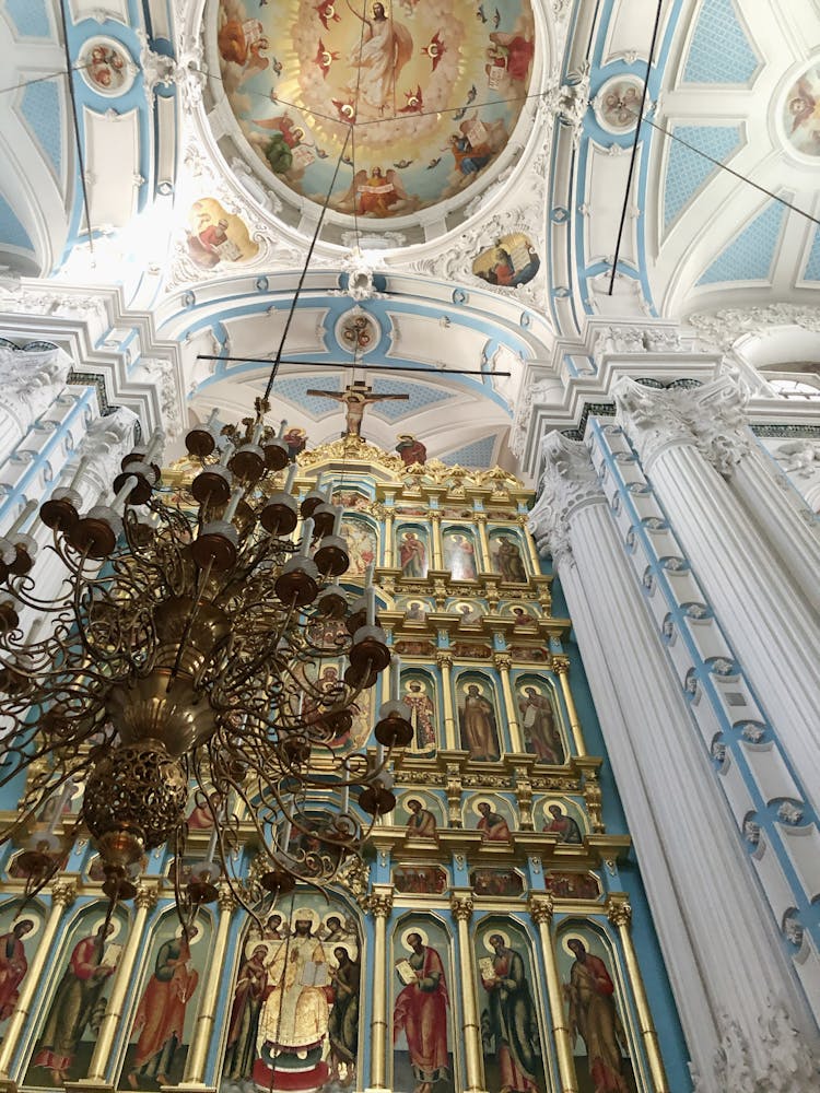 Golden Chandelier Hanging From A Dome Ceiling