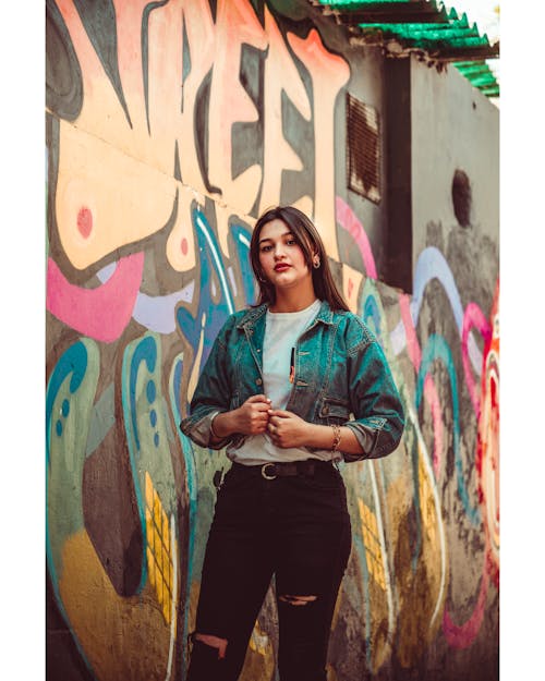 A Woman Standing Beside a Graffiti Wall
