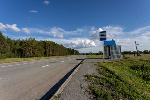 Free A quiet rural road with an empty bus stop under a clear blue sky in Sinitsyna, Russia. Stock Photo