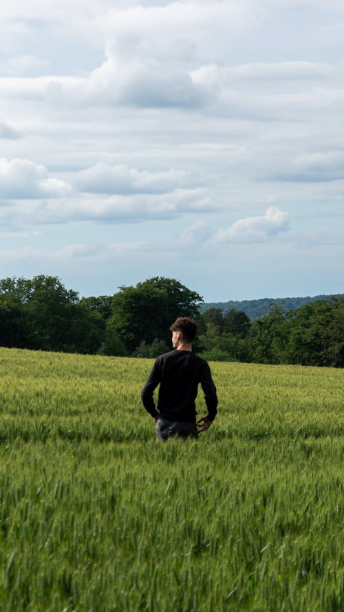 Man in Black Long Sleeves Standing on Green Grass Field