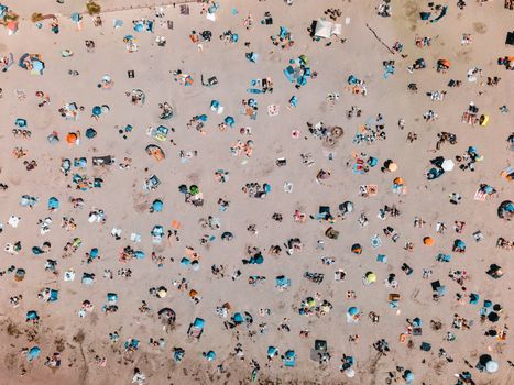 Drone shot capturing summer beachgoers enjoying the sun at West Wittering, UK.