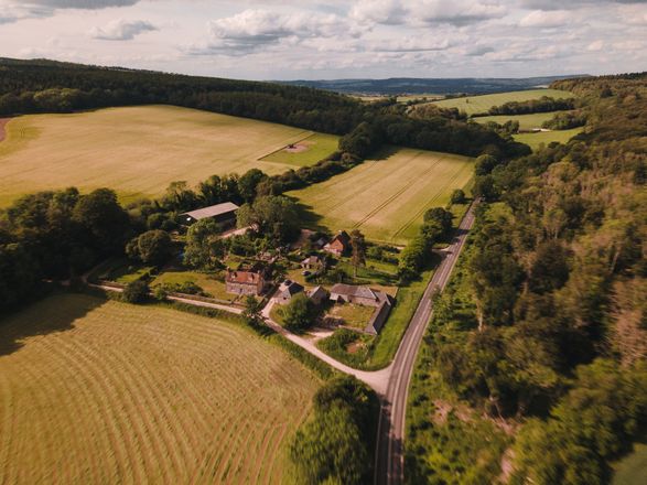 Aerial view of a UK farmhouse and fields representing a mixed-estate landlord with agricultural property and a wider portfolio