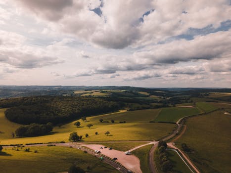 Aerial view of picturesque countryside landscape with fields and forests in West Sussex, England.