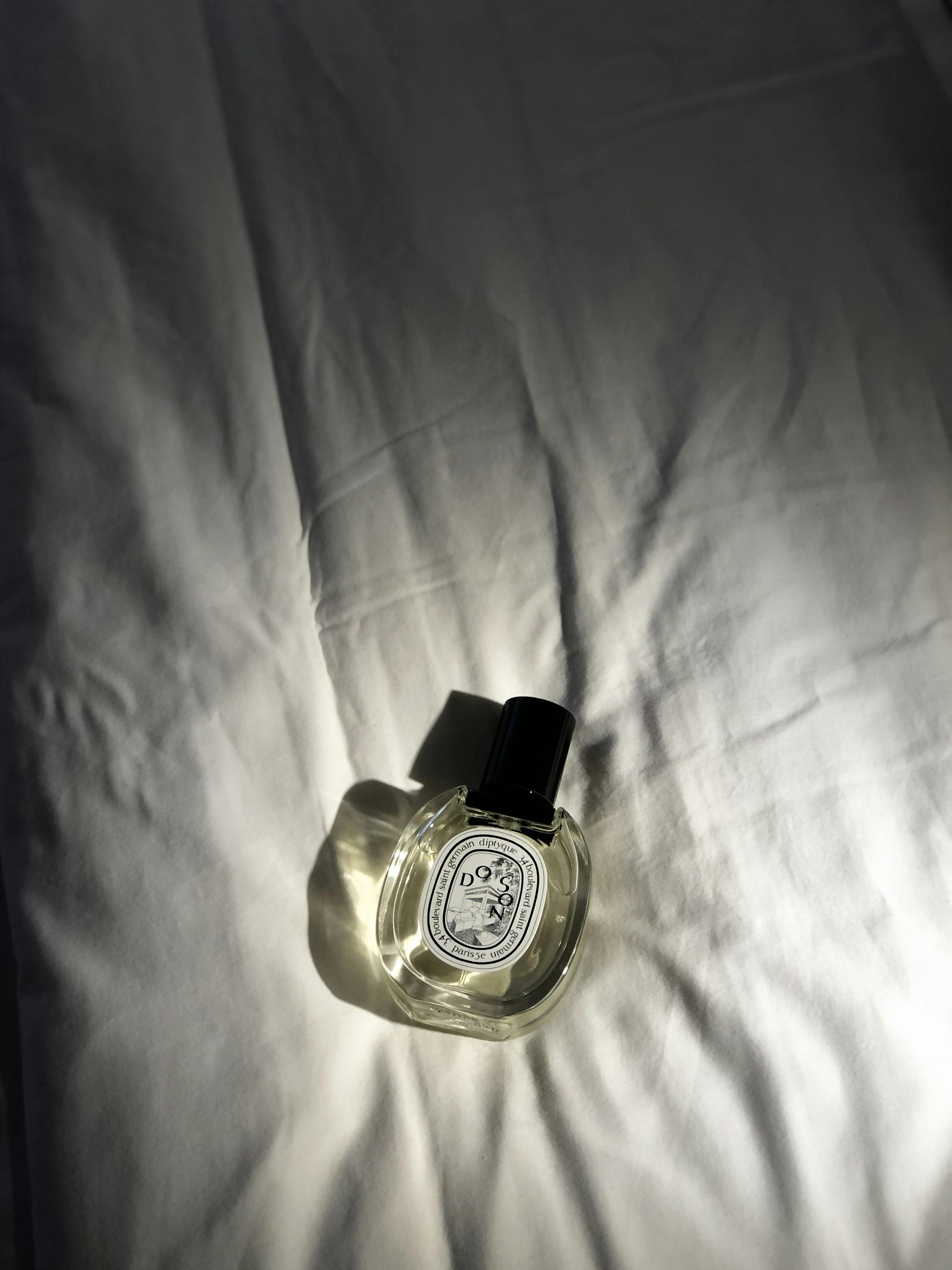 Perfume Bottle on a Bed · Free Stock Photo