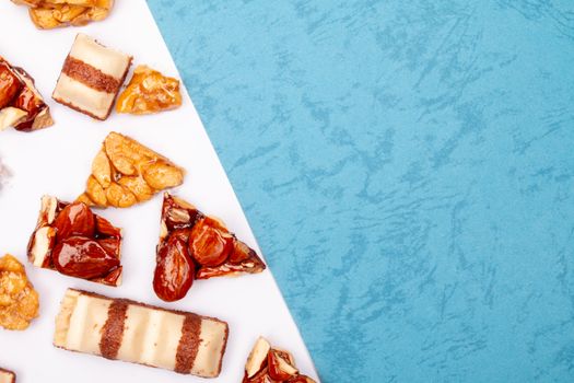 Delicious assorted candied nuts arranged on a blue textured background, perfect for food photography.