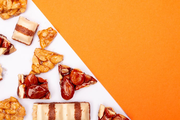 Caramelized Almonds And Nuts On Orange And White Surface