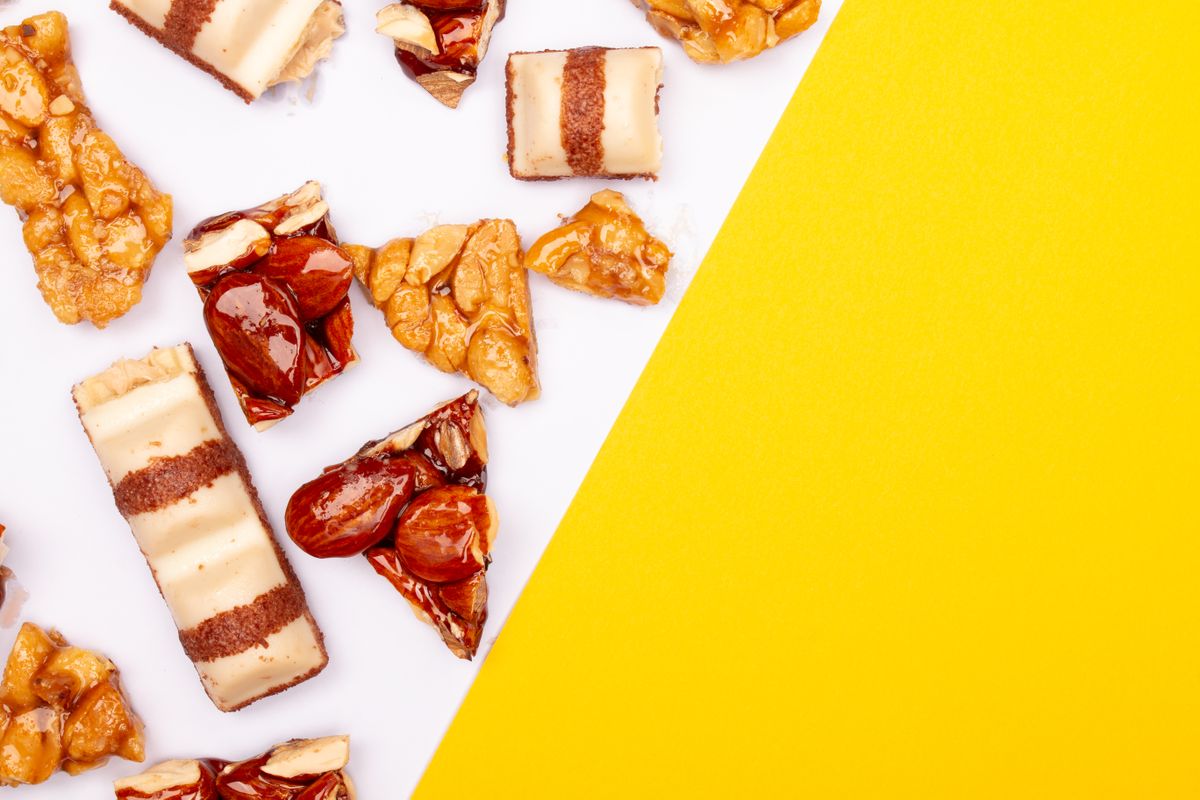 Top view of mixed candy and nougat on yellow and white background. Perfect for sweets lovers.