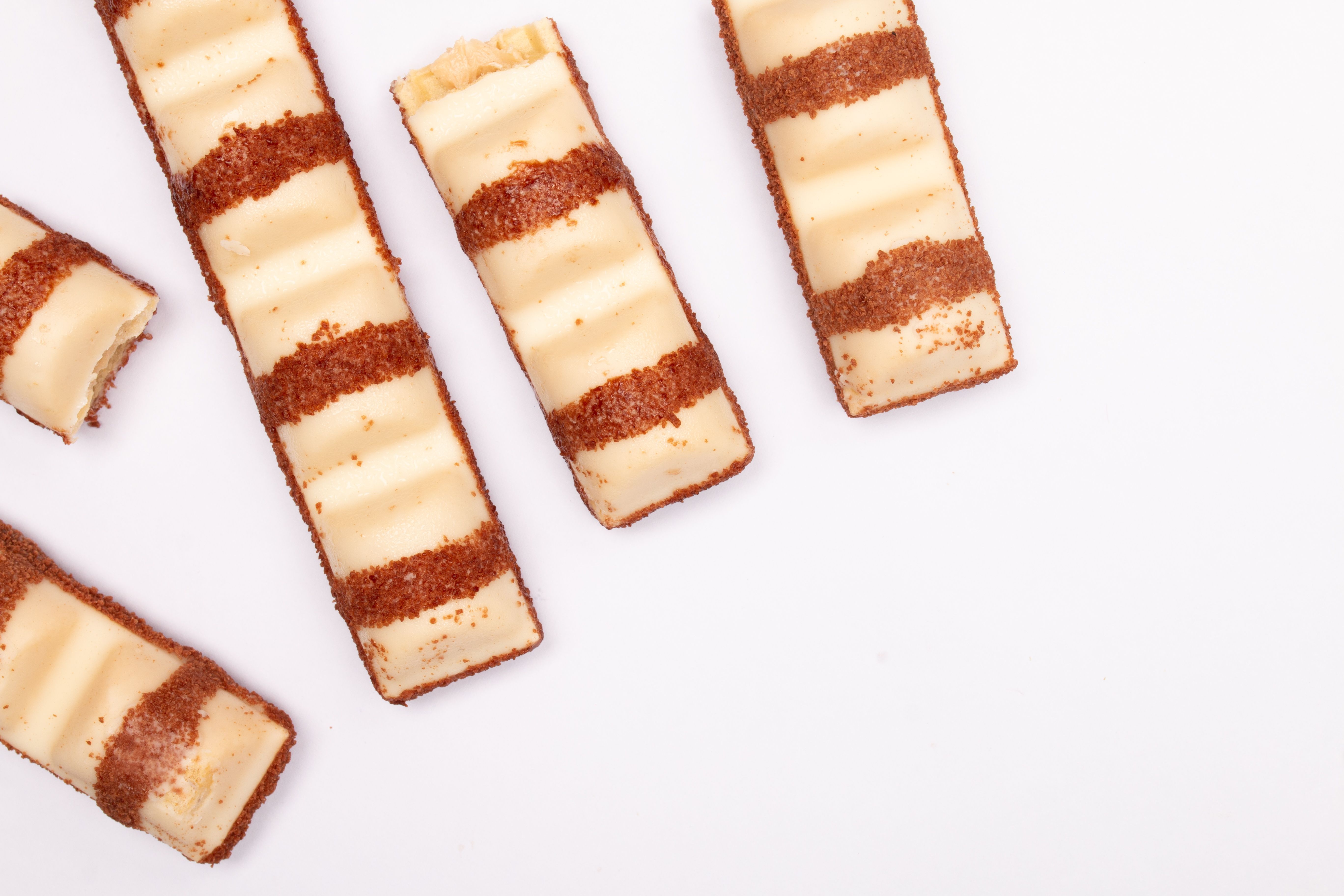 Top view of chocolate wafer bars with cream filling on white background.