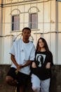 Man in White Crew Neck T-shirt Standing Beside Woman in Black Tank Top