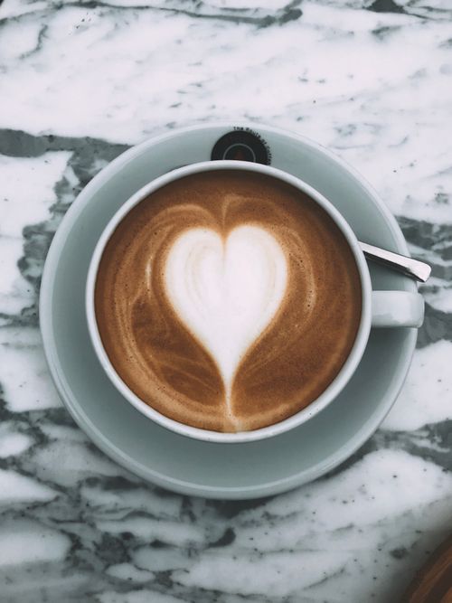Free A beautifully crafted heart-shaped latte art in a ceramic cup on marble. Stock Photo