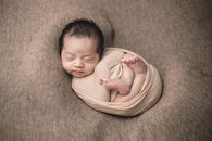 Baby in Yellow Shirt Lying on Brown Textile