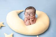 Topless Boy Wearing Black Framed Eyeglasses Lying on Yellow Banana Bed