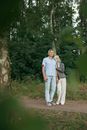 Man and Woman Standing on Dirt Road Between Trees