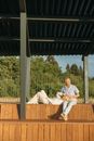 Man in White Dress Shirt Sitting on Brown Wooden Bench