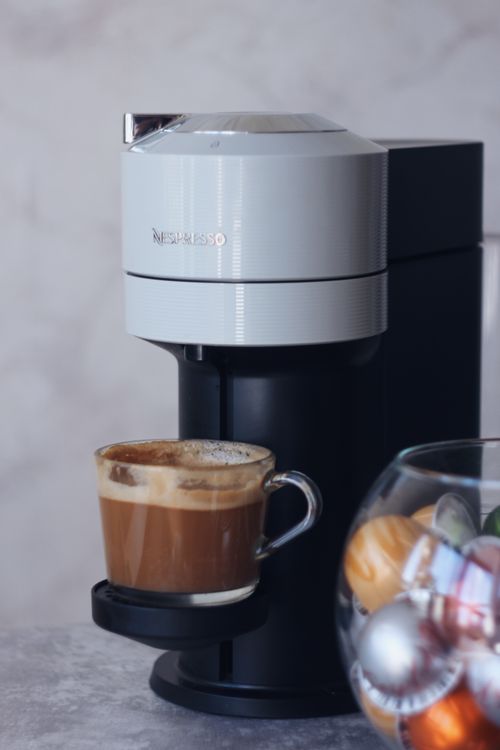 Free Sleek coffee machine dispensing a fresh cup of coffee in a cozy kitchen. Stock Photo