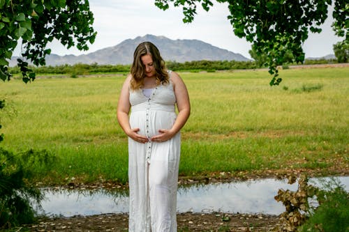 Free Pregnant Woman looking at her Baby Bump  Stock Photo