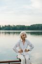 Woman in White Long Sleeve Shirt Standing Near Lake